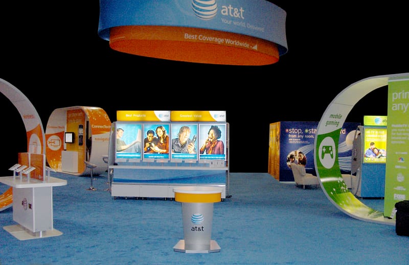 Photo of a large trade show booth with multiple touch points and graphics hanging from the ceiling.